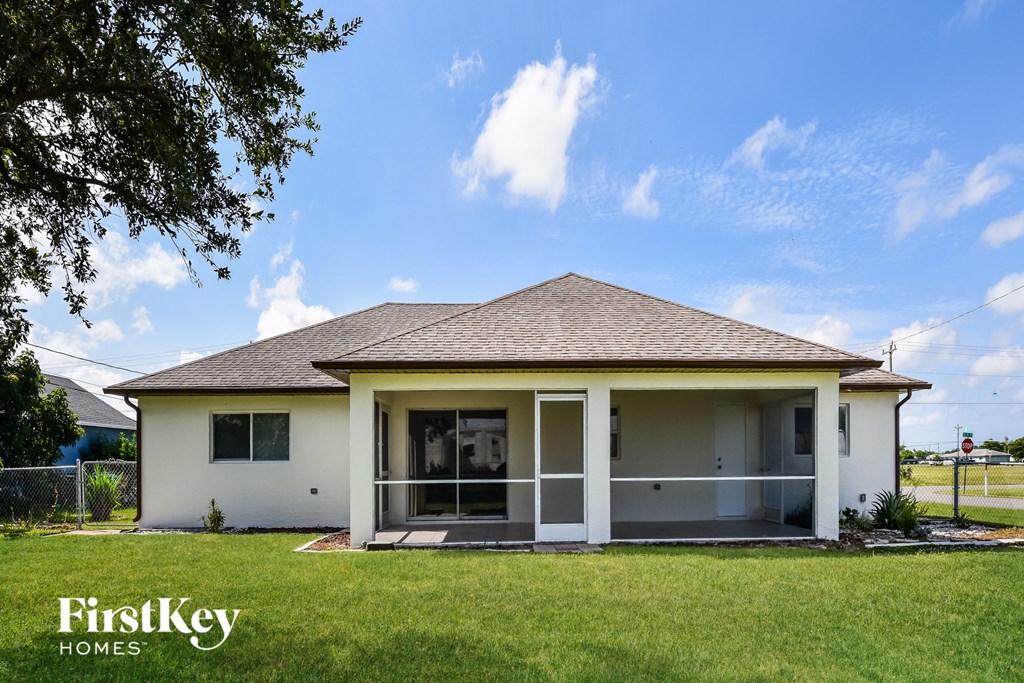 a small white house with a lawn and a blue sky