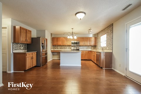 A kitchen with wooden cabinets and a white island.