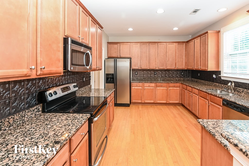 a kitchen with granite counter tops and wooden cabinets