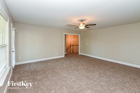 a living room with carpet and a ceiling fan