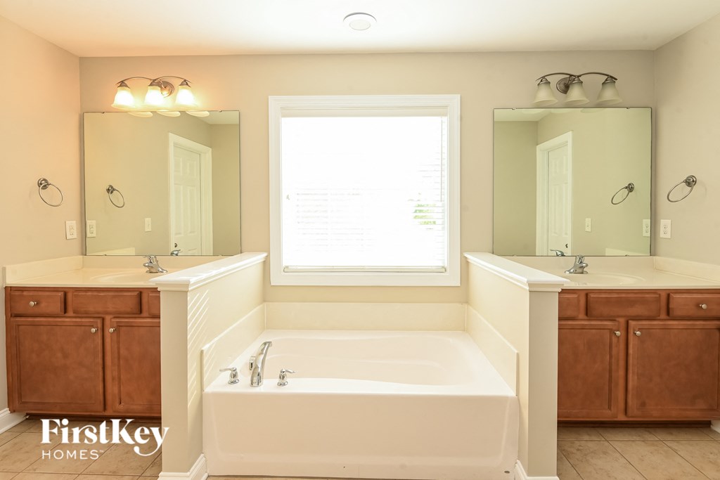 a bathroom with a large tub and two sinks