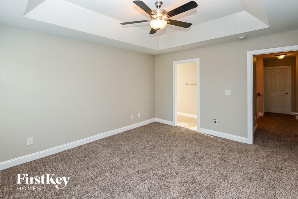 the master bedroom is spacious and has a ceiling fan