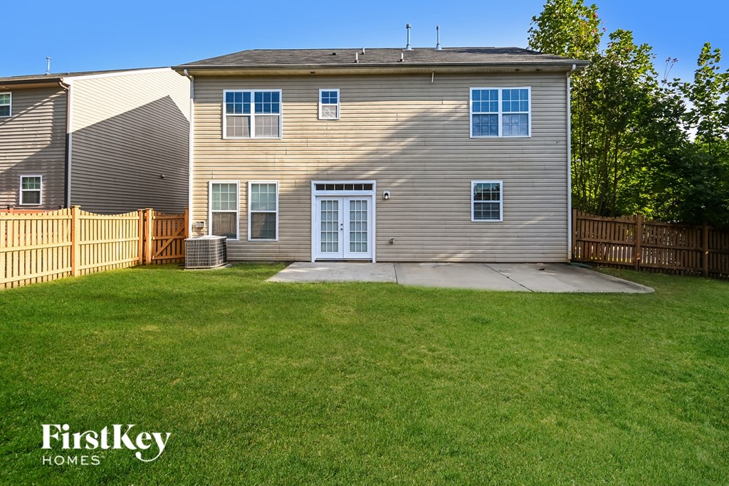 a white house with a yard and a fenced in back yard