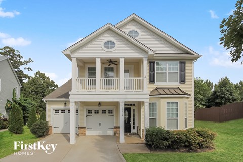 a white house with a porch and a driveway