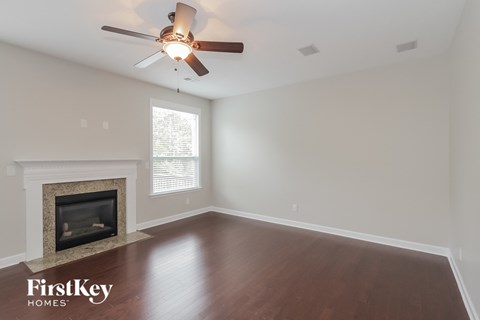 a living room with a ceiling fan and a fireplace