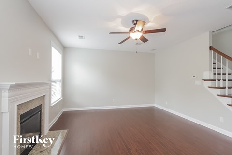 a living room with a fireplace and a ceiling fan