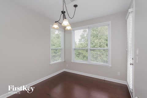 an empty room with three windows and a chandelier