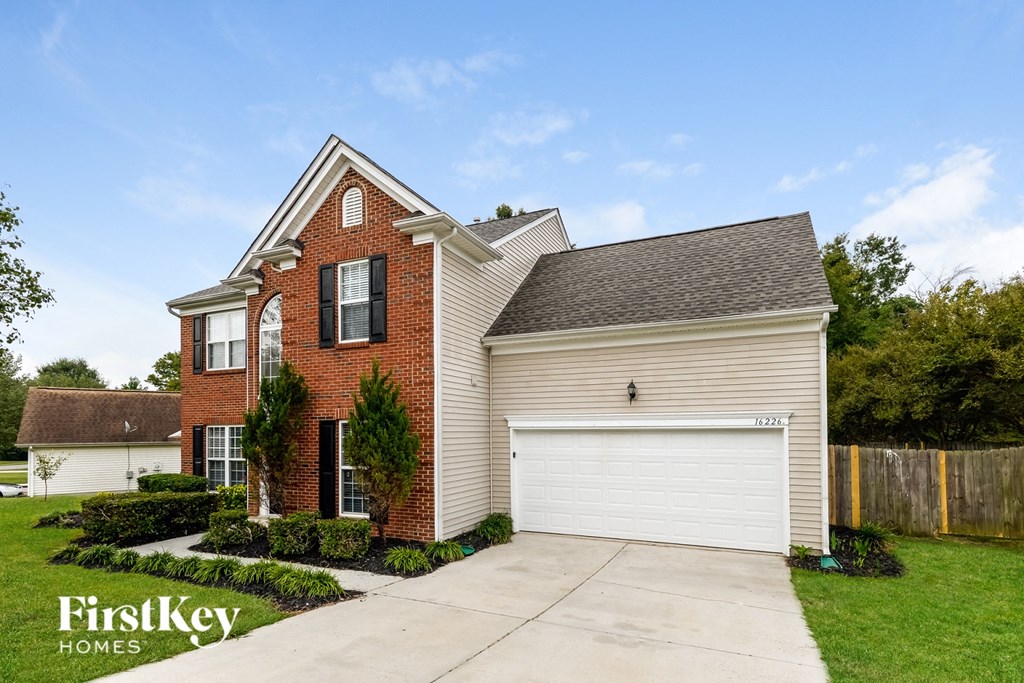 A brick house with a garage is for sale.