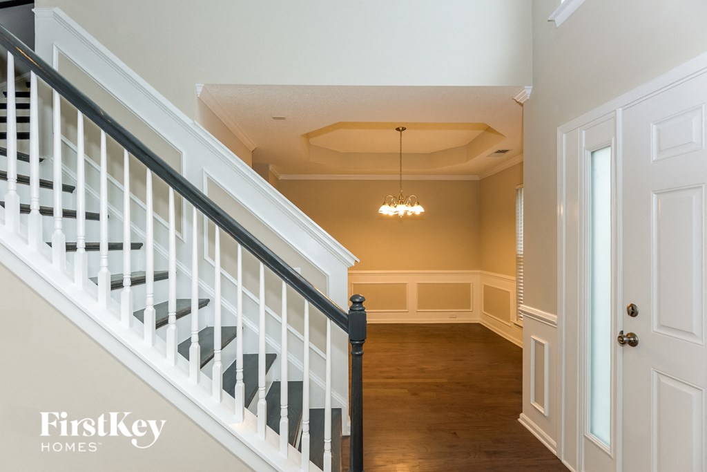 A staircase with a chandelier in the middle of the room.