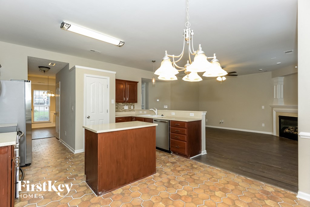 A kitchen with a tile floor and a chandelier hanging from the ceiling.