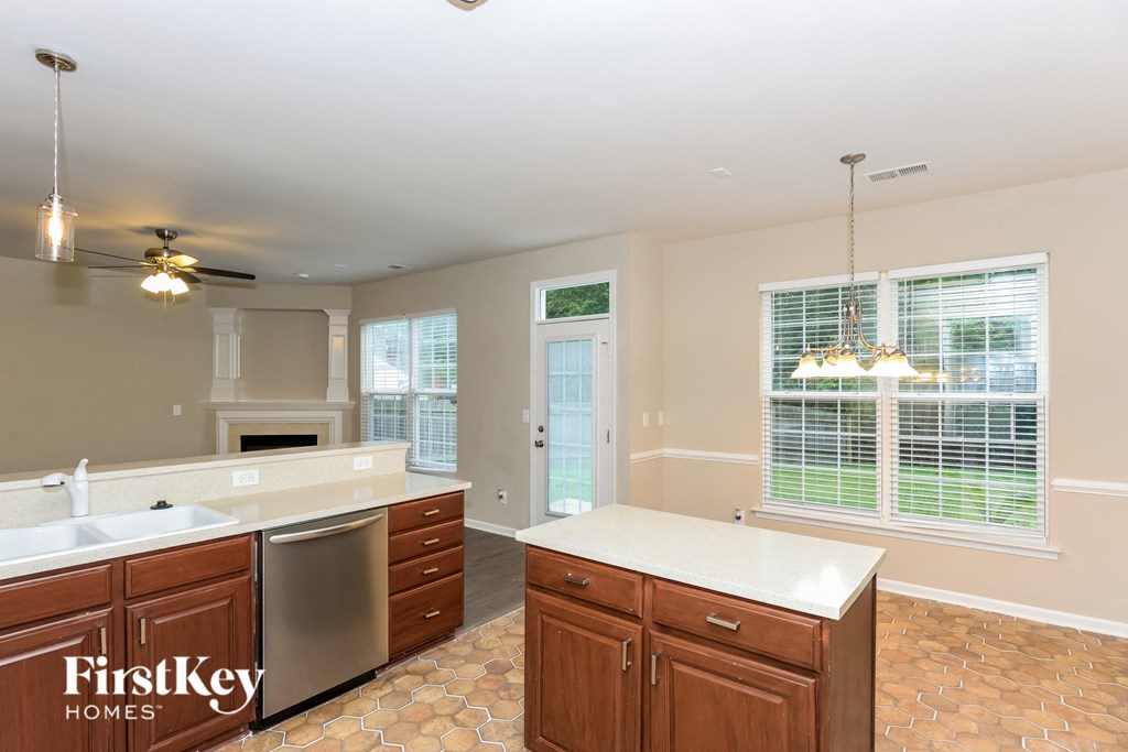 A kitchen with a tile floor and a ceiling fan.