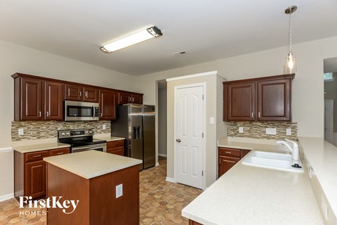A kitchen with brown cabinets and a white counter top.