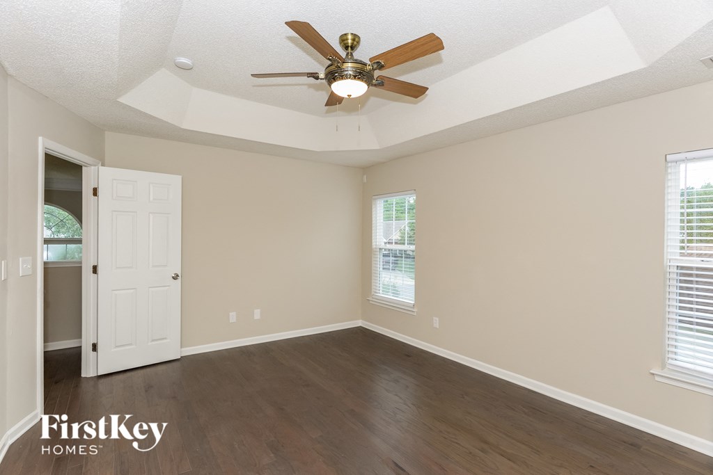 A room with a ceiling fan and a door.