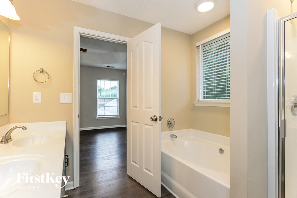 A white bathroom with a tub and sink.