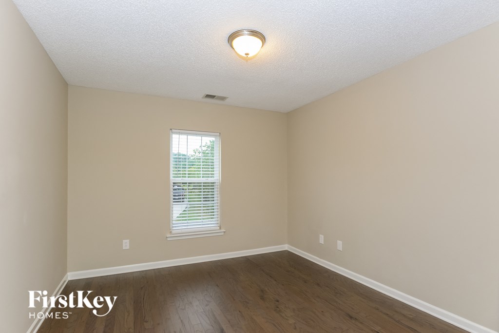 A room with a window and wooden floors.