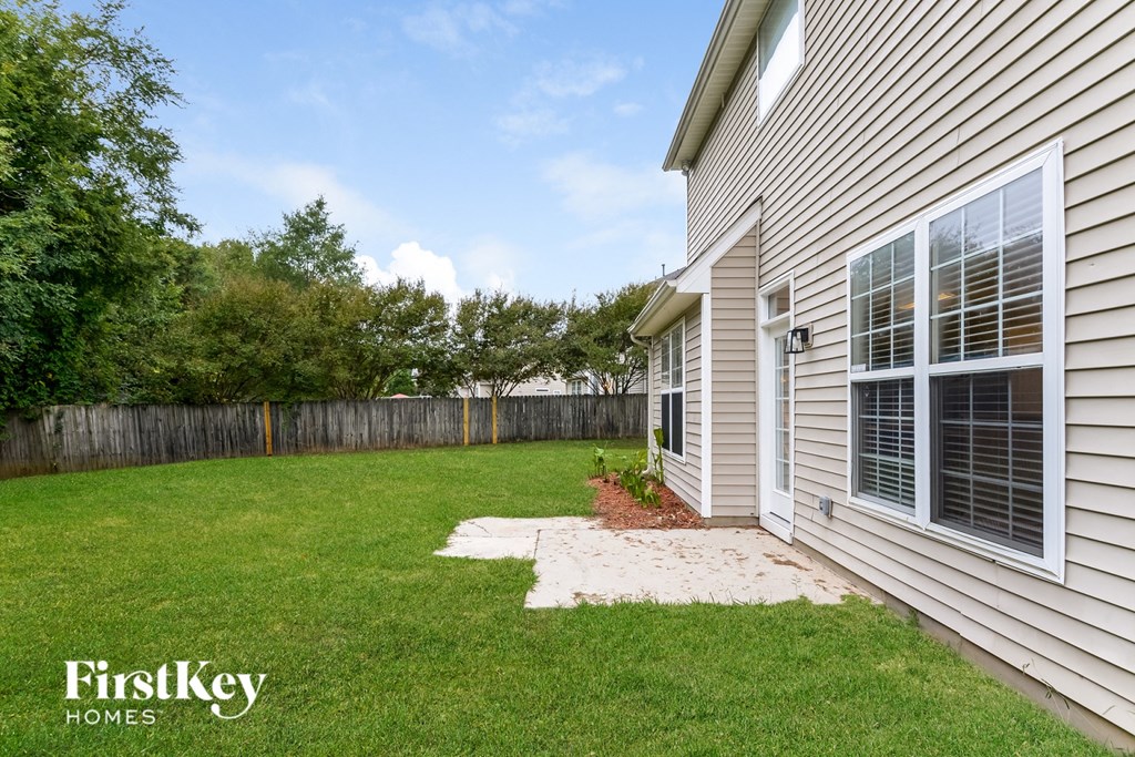 A house with a fence and a small garden in front.