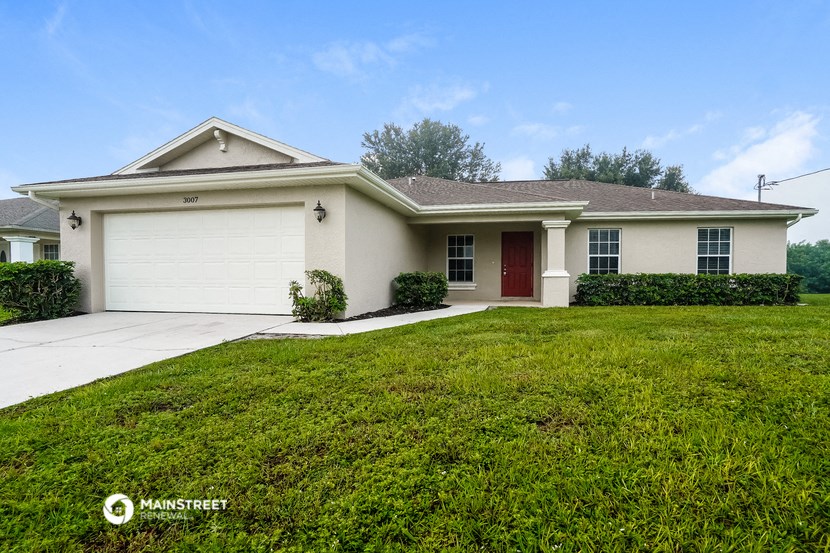 a white house with a lawn and a driveway