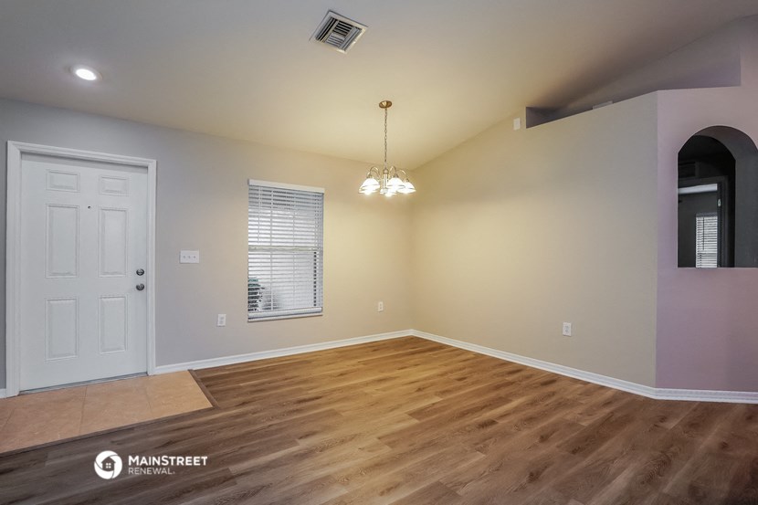 the living room after remodeling with hardwood flooring and a white door