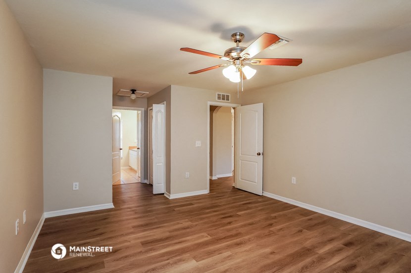 a living room with a ceiling fan and wood flooring