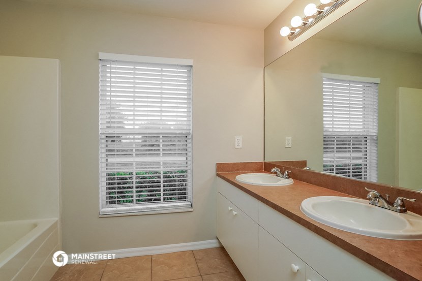 a bathroom with two sinks and a large mirror