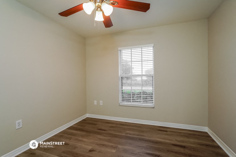 a bedroom with a ceiling fan and a window