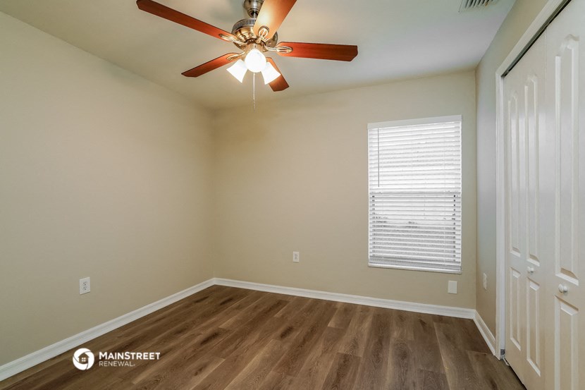 the ceilings in this spacious bedroom are painted beige and have a ceiling fan