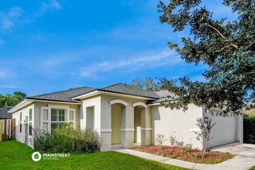 a white house with a tree in front of it