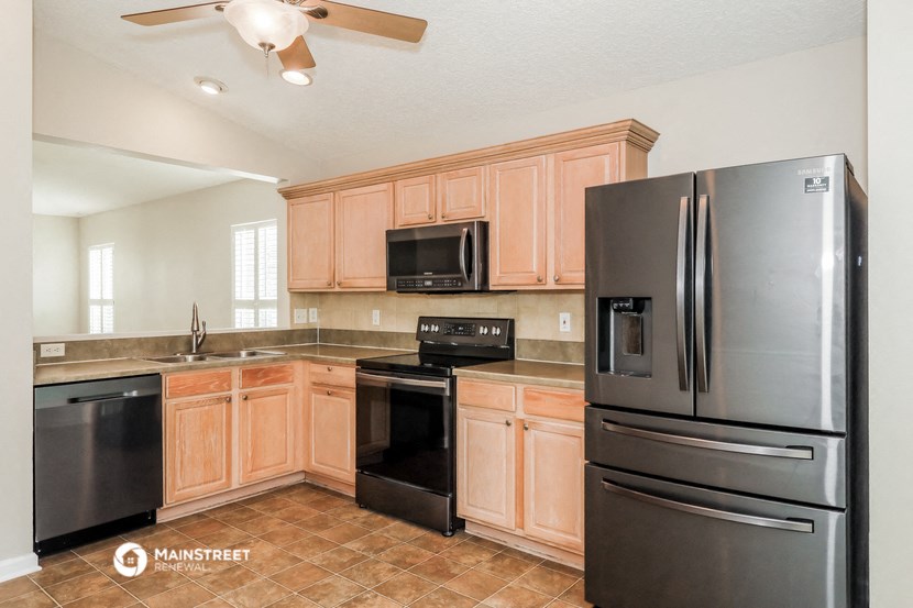 a kitchen with black appliances and wooden cabinets