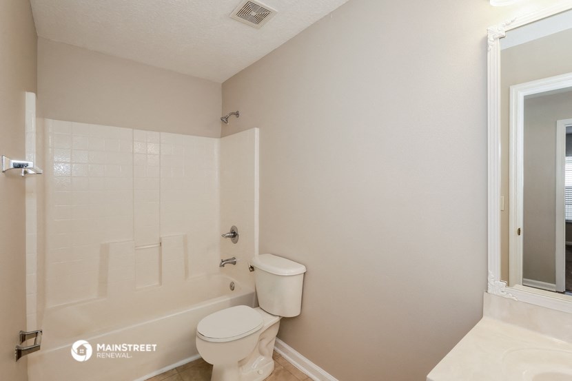 a bathroom with a toilet and a tub and a sink