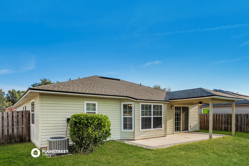 a small white house with a backyard and a patio
