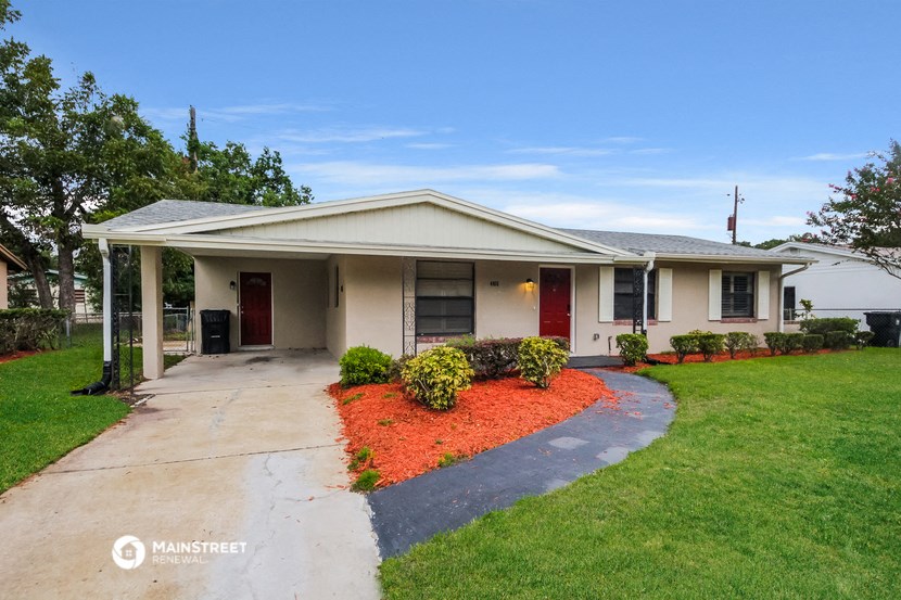 a home with a driveway and lawn in front of it