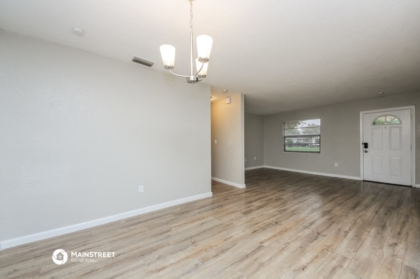 the spacious living room and dining room with wood flooring