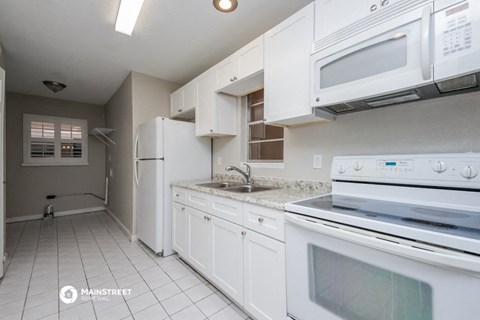 a white kitchen with white appliances and white cabinets