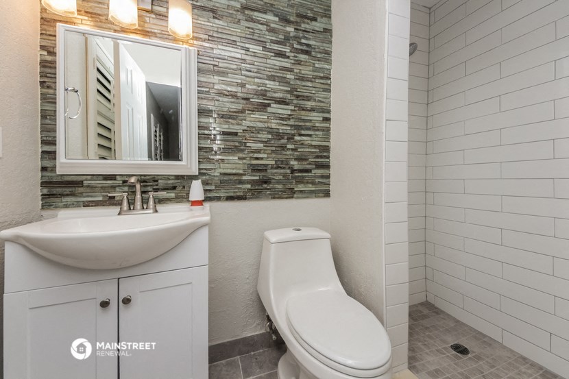 a bathroom with a toilet and a sink and a mirror