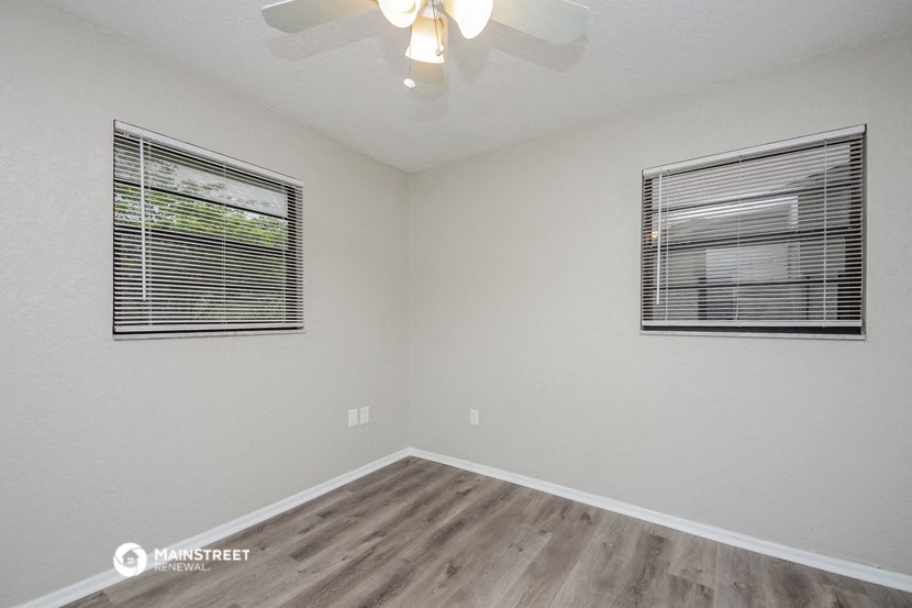 the living room of our studio apartment atrium with wood floors and a ceiling fan