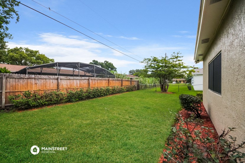 a backyard with a fence and a garden and a greenhouse