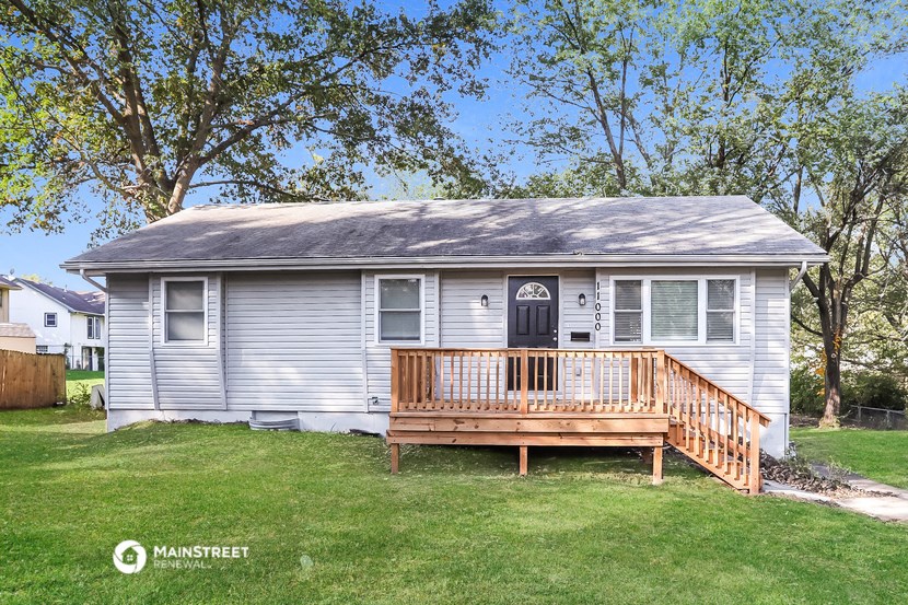 a white house with a porch and a wooden deck