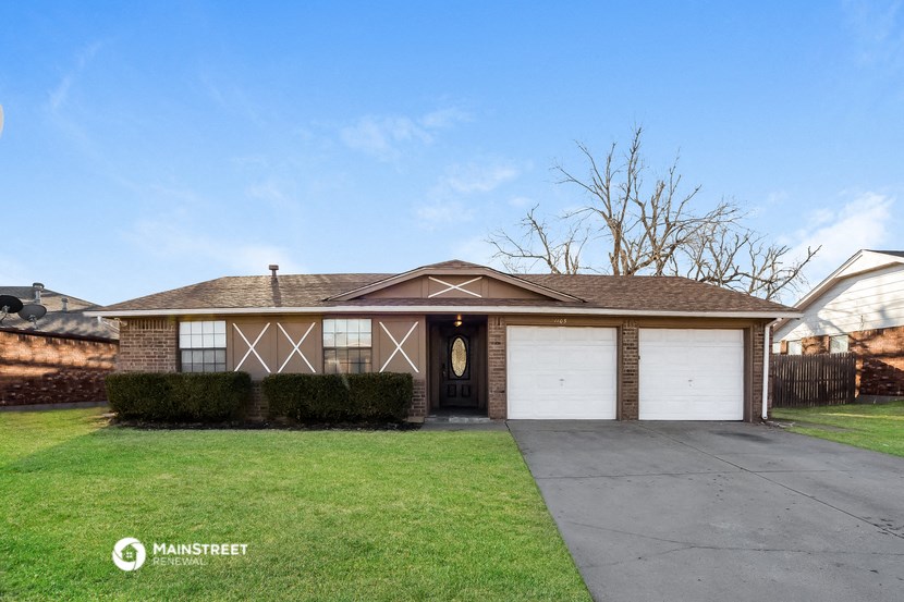 a brick house with two garage doors and a driveway