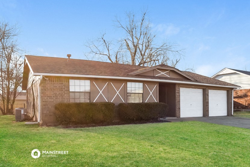 a brick house with two white garage doors
