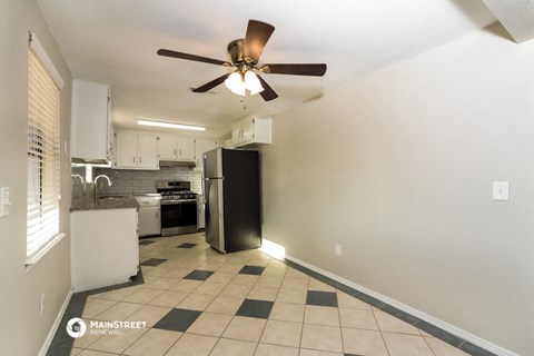 a kitchen with a ceiling fan and a refrigerator