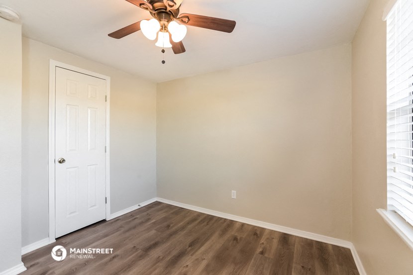 a bedroom with a ceiling fan and a white door