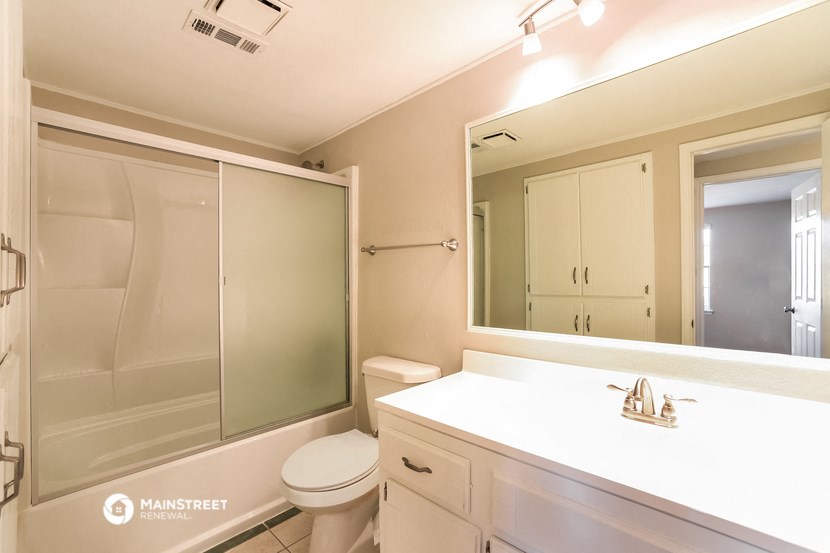 a bathroom with a large mirror and a toilet and a sink