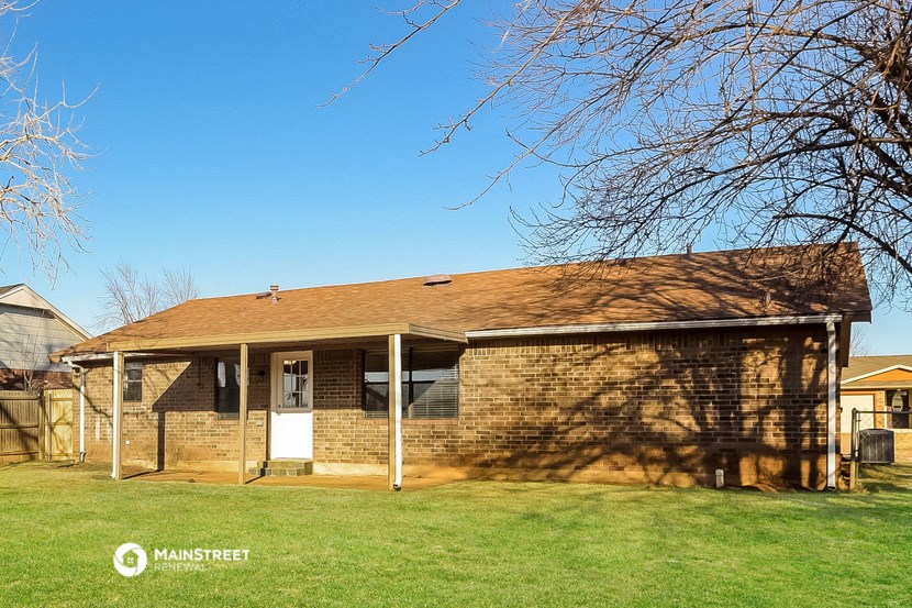 a brick house with a yard and a tree