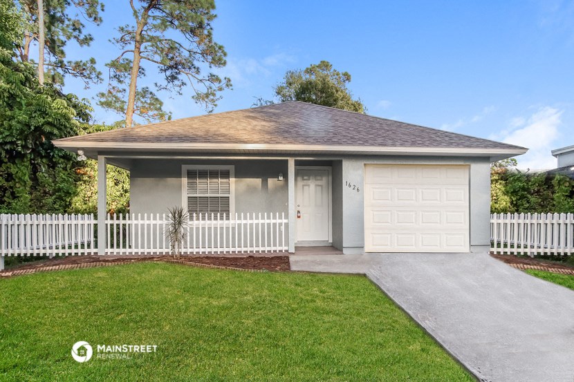 a white house with a white fence and a garage door