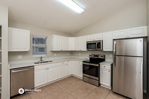a kitchen with white cabinets and stainless steel appliances