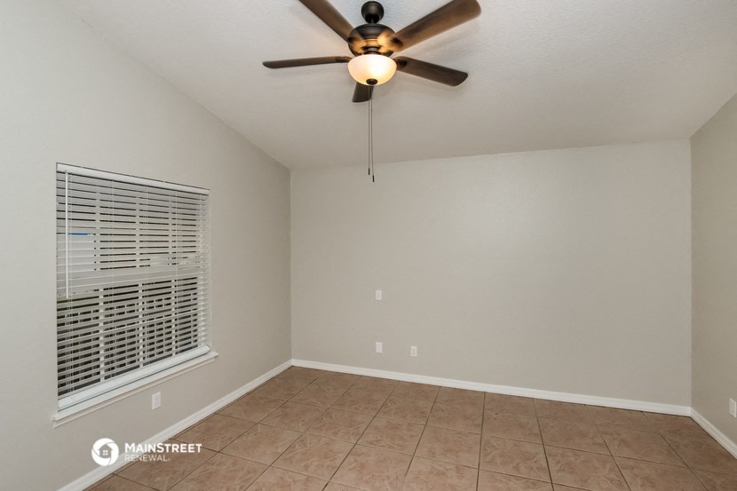 a living room with a ceiling fan and a window