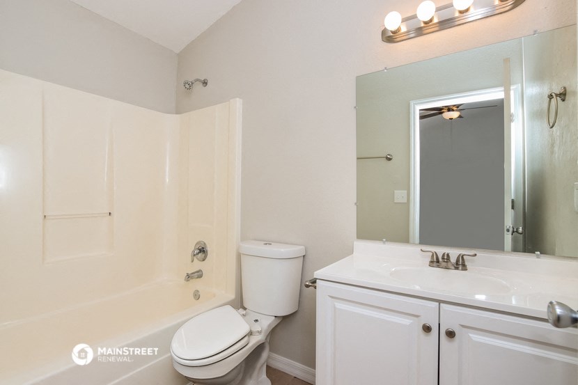 a bathroom with a sink toilet and a mirror
