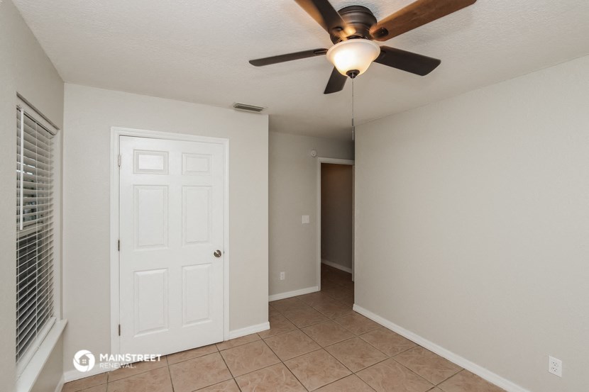 a bedroom with a ceiling fan and a closet