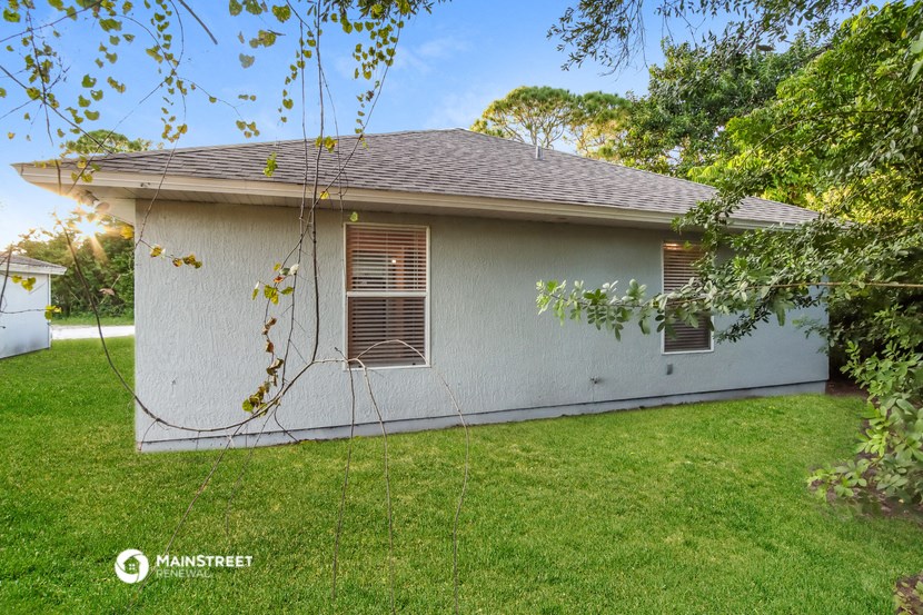 a white house with a yard and a tree