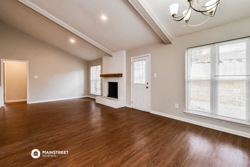 the living room with wood flooring and a fireplace